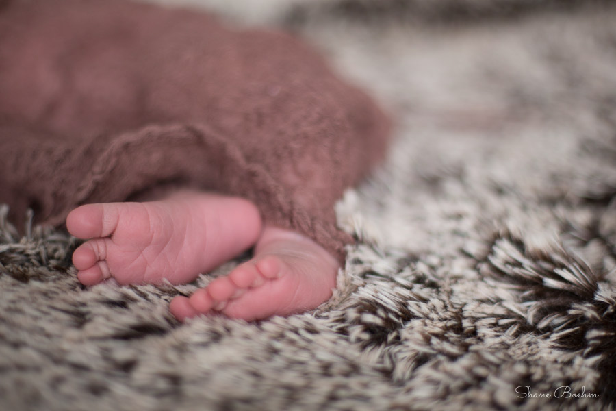 Newborn feet in brown cheesecloth
